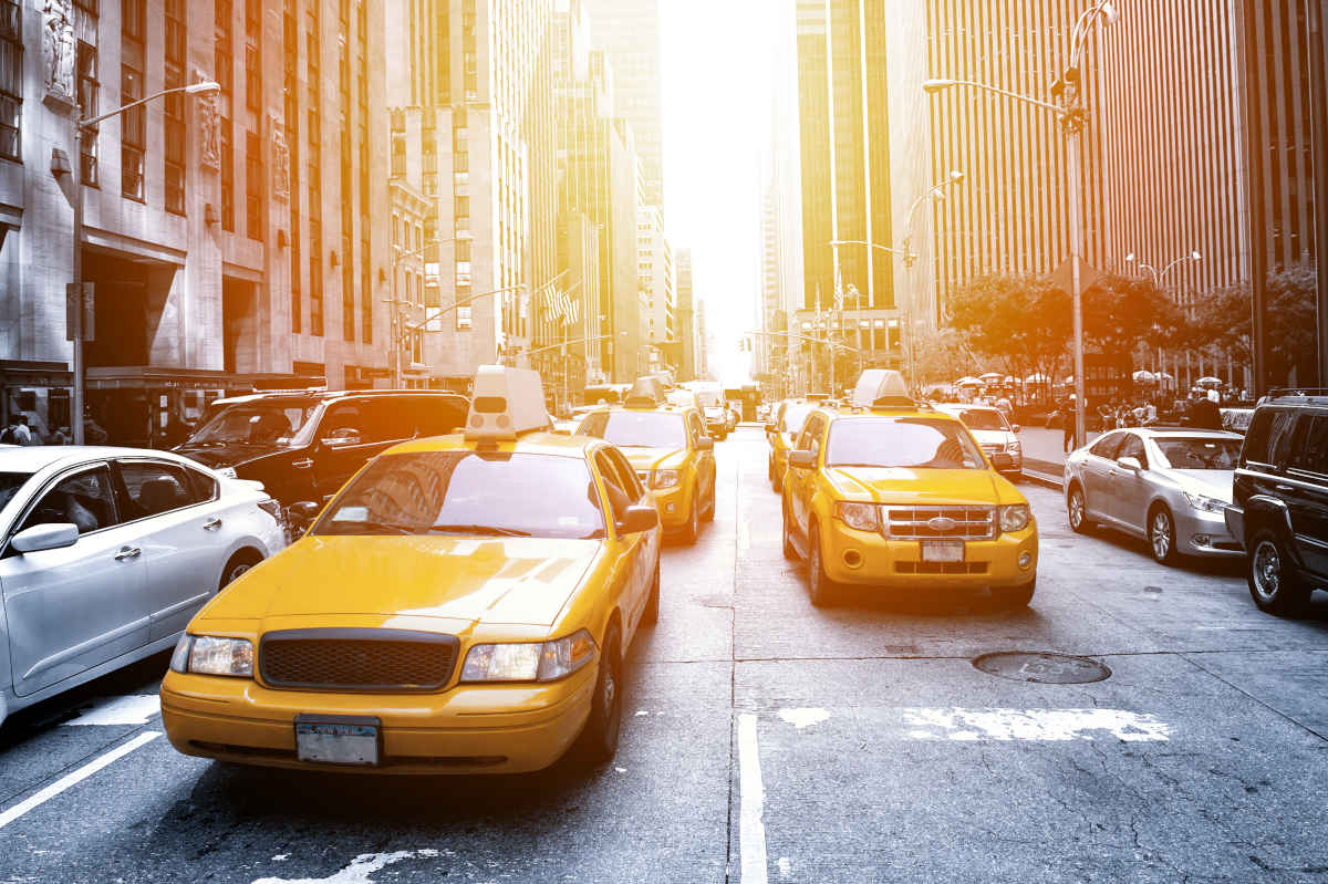 Eine Flotte von Taxis, die auf einer Straße fahren.