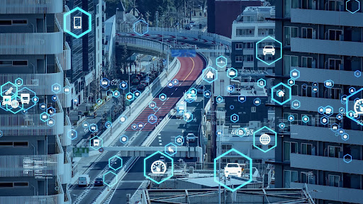 Dichte städtische Verkehrslandschaft, überlagert mit futuristischen digitalen Grafiken, um die Konnektivität und den Datenaustausch zwischen Fahrzeugen und Infrastruktur anzuzeigen.