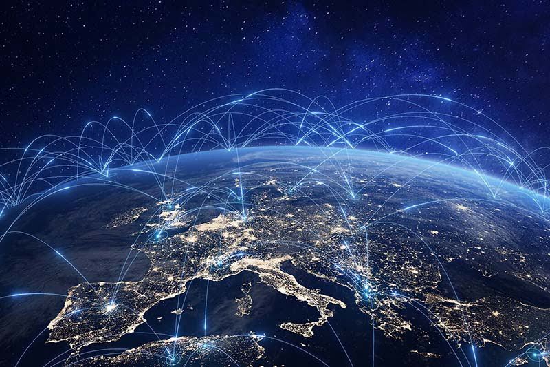 Drahtlose Kommunikationsnetzwerke, visualisiert als Lichtbänder, die sich von Stadt zu Stadt über ein Satellitenbild von Europa bei Nacht bewegen.